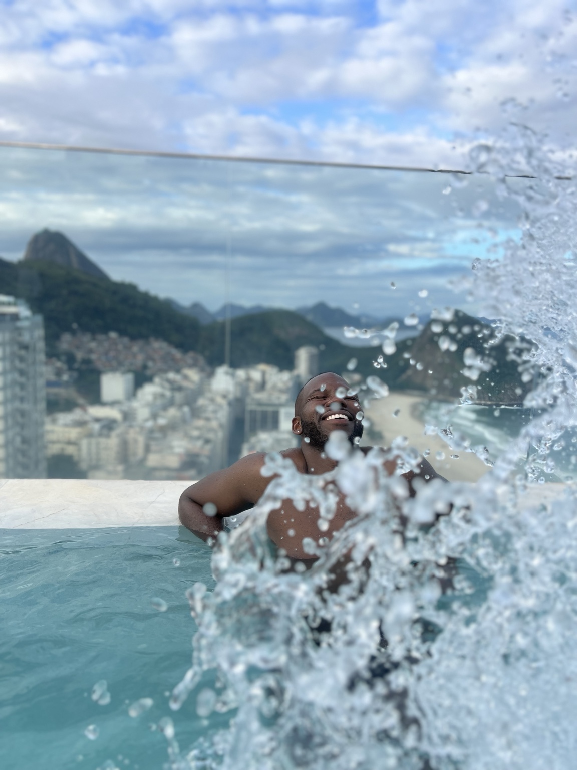 Joyful pool portrait with splashing water and Rio de Janeiro in the background